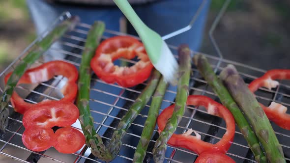 Making Grilled Vegetables Brushing Oil on Asparagus and Red Pepper on a Charcoal Grill