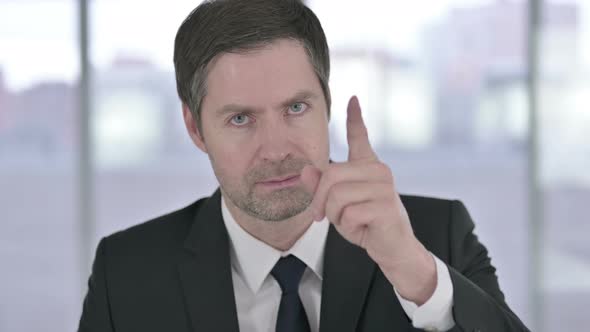 Portrait of Middle Aged Businessman Pointing Finger and Inviting