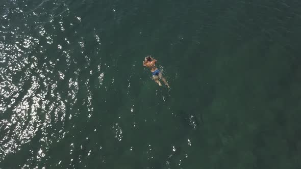 Sexy Masculine Guy in Blue Brief Swimwear Enjoys Swimming in Ocean on Summer Day