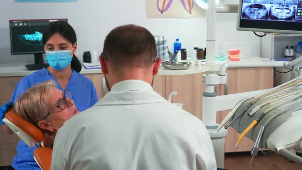 Dentist and Assistant Work with a Patient in Modern Dental Clinic