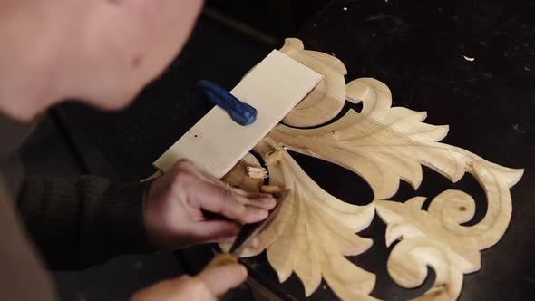 Carpenter Working on a Wooden in His Workshop on the Table Preparing a Detail of Wooden Product a