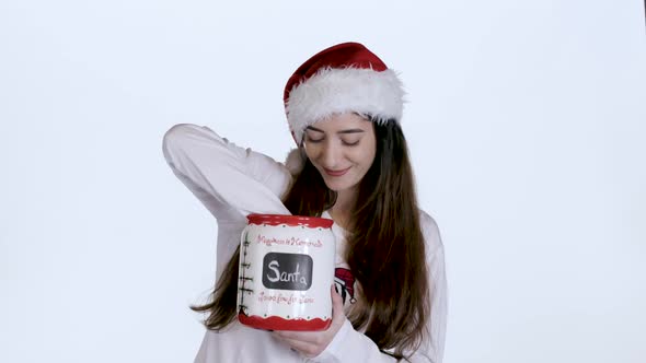 Young woman Taking Cookies out of Christmas Cookie Jar (White Screen)