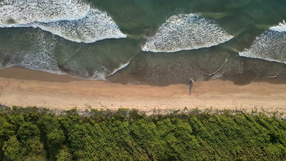 Trucking aerial cameraement vertically above playa Ventanas in Tamarindo, Costa Rica. Drone flying a