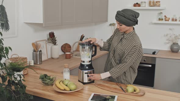 Woman in Hijab Making Smoothie in Kitchen