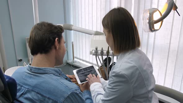 Dentist and Patient Looking at Dental X-ray