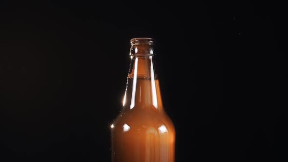 Using the Beer Bottle Opener in Slow Motion on the Black Background, Smoke Comes From the Bottle