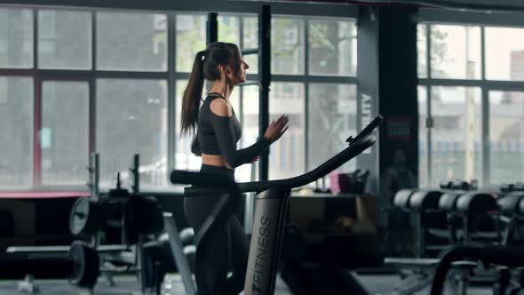 Woman athlete athlete is engaged in cardio training on the treadmill, thin beautiful sports girl