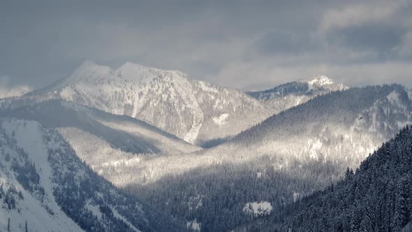 Rolling Cloud Shadows Time Lapse On Snow Covered Mountain Hills With Thick Forest Trees