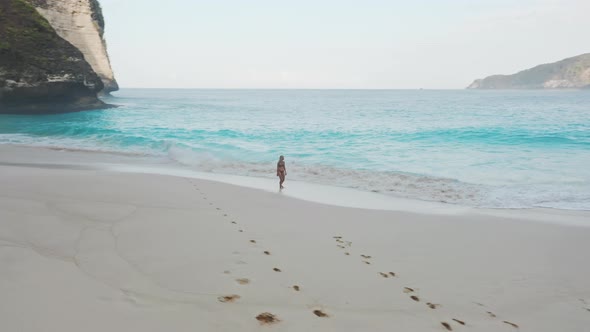 Woman Enjoying the Peaceful Scenery As She Walks on the Shore and Water