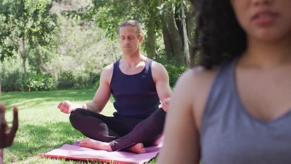 Caucasian man meditating and practicing yoga at the park