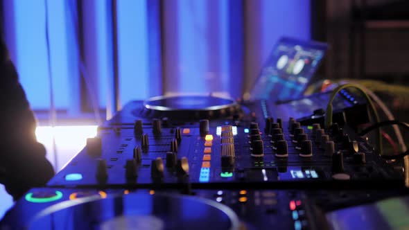 Close Up Dj Hands Disc Jockey Mixing Music on His Deck with His Hands Poised Over the Vinyl Record