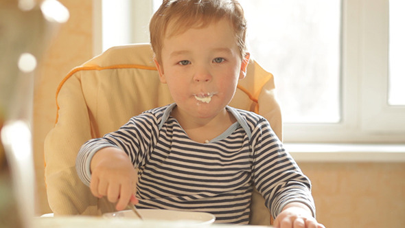 Little Boy Eating Porridge In The Morning 