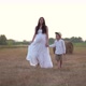 Beautiful Pregnant Woman with Son Walking in Wheat Field with Haystacks at Summer Day - VideoHive Item for Sale