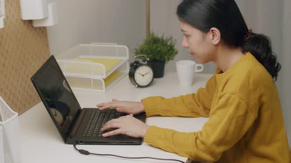 Businesswoman typing keyboard and scrolling touchpad on a laptop.