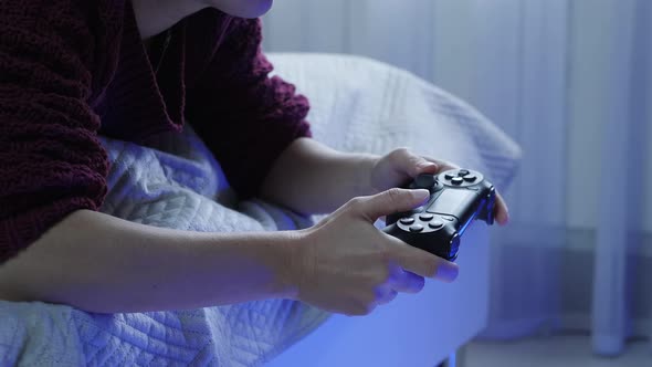 Close up of female hands holding video game wireless joystick controller