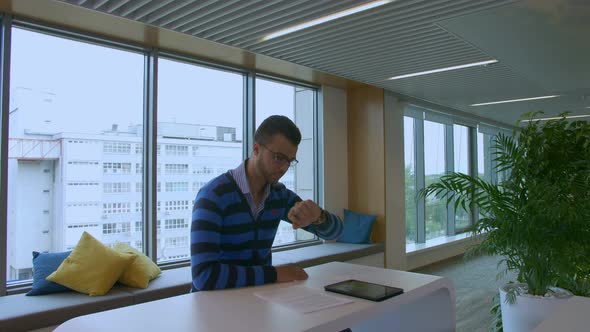 Medium Shot of Annoyed Man in Suit Sitting in Office Reception Area.