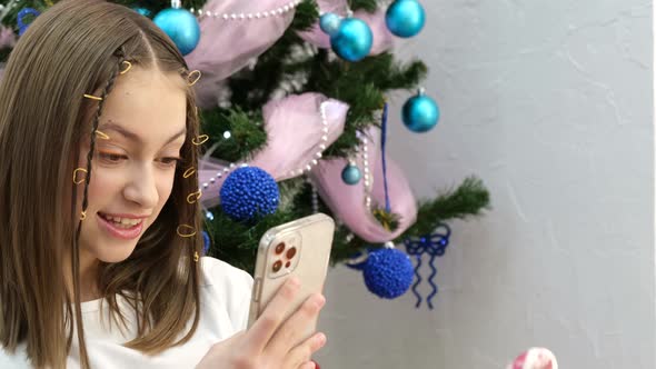 European Teenage Child is Photographed Near the Christmas Tree at Home New Year's Mood