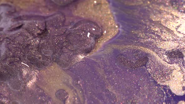 Gold, pink, lilac, purple paint. Liquid glitter texture