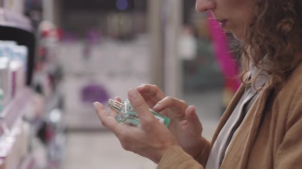 Woman Examining Perfume Bottle In Beauty Shop