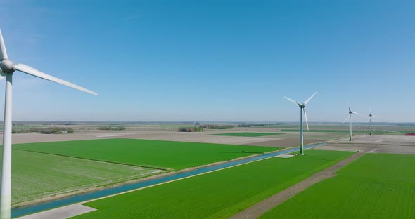 Wind turbines spinning and generating clean energy in Holland, with classic water canal