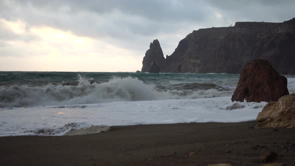 A Red Burning Sunset Over the Sea with Rocky Volcanic Basalt Cliff