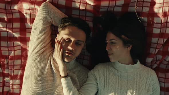 Engaged Couple Lying In The Field at Sunset