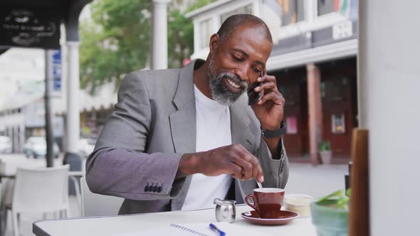 African American man talking by phone in a coffee