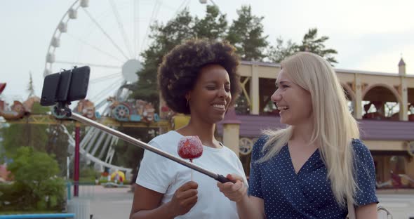 Diverse Young Women Taking Selfie on Smartphone in Amusement Park