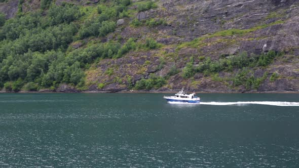 Small Motor Boat with Tourists in Norway Fjord