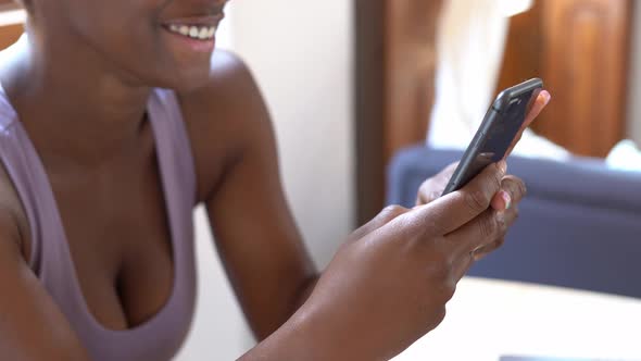 Content black woman using smartphone at table