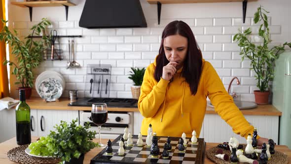 Young Woman Playing Chess on Kitchen Table