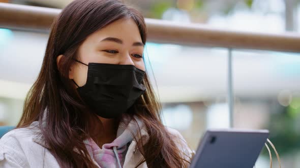 Asian Woman in Mask Browsing Internet
