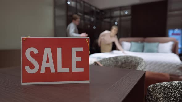Sale Message on Table in Furniture Store with Blurred Buyer and Seller Talking Discussing