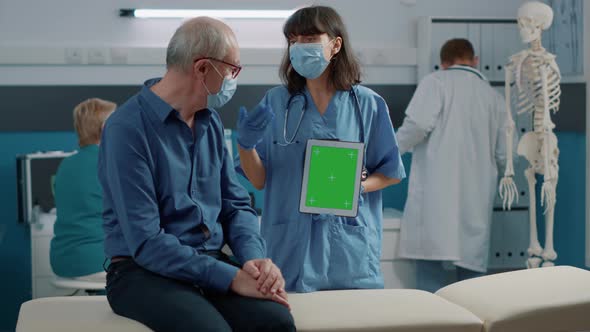 Nurse and Retired Man Looking at Green Screen on Digital Tablet