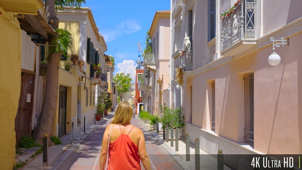 4K Back view of young tourist woman walk down small Greek road in Athens, Greece