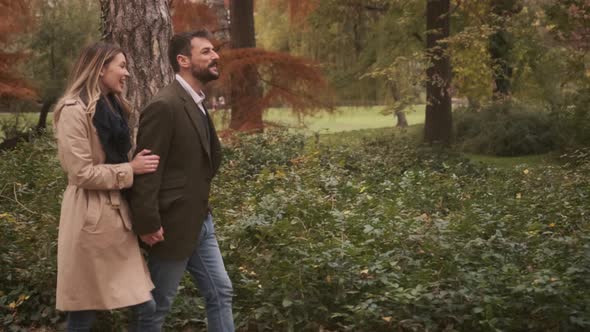 Handsome young couple walking in the autumn park