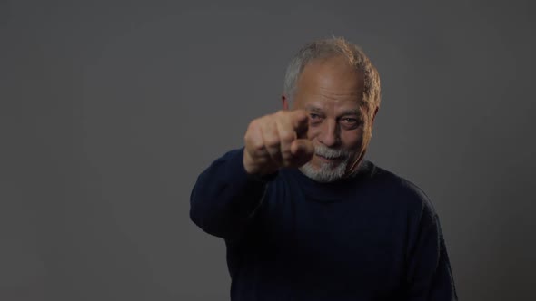 Man Looks Straight at Camera and Shows with Index Finger