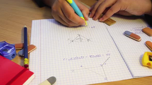 The Hands of a High School Student Solve a Geometric Problem in a Notebook