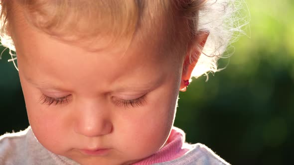 Happy Little Girl Sitting on the Green Grass