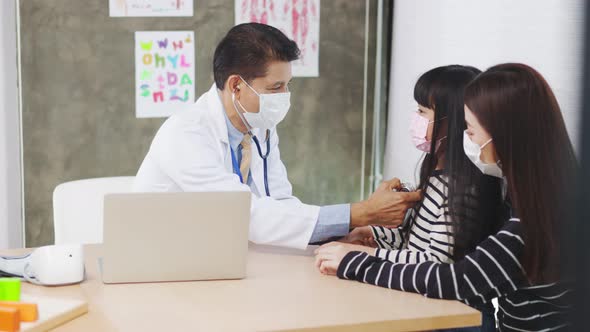 Asian  senior doctor wearing gloves and isolation mask is making a COVID-19