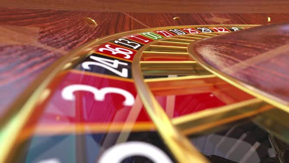 Closeup view at casino roulette table with rotating wooden roulette wheel