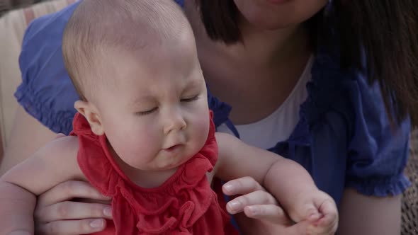 Up close slow motion of woman bouncing baby girl on her knee.