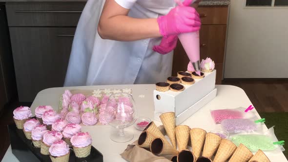 A Woman Makes Marshmallows In Waffle Cones. With A Pastry Bag