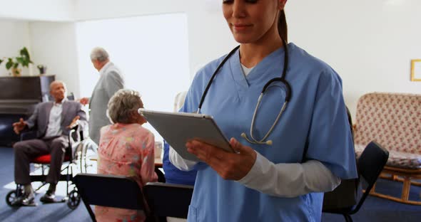 Front view of Caucasian female doctor using digital tablet at nursing home 4k