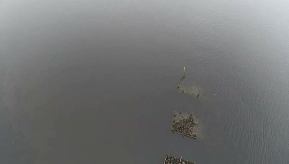 Flying over unfinished wooden bridge in the sea