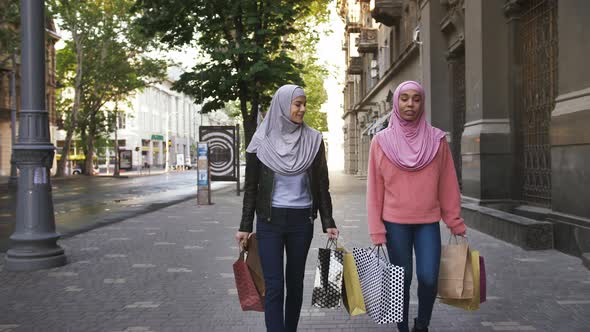 Two Muslim Darkskinned Females in Casual Clothes and Colorful Hijabs