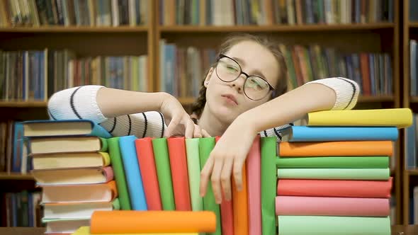 Girl with Books in the Library Comes Up with a New Idea