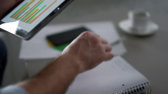 Manager Writing Graph Chart Using Digital Tablet Device in Home Office Cafe