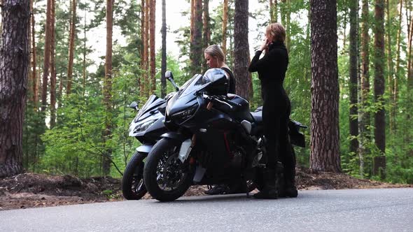 Motorbikes in the Forest Two Adult Women Walks to Their Motorcycles on the Empty Narrow Road and