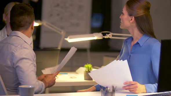 Business Team with Papers Working Late at Office